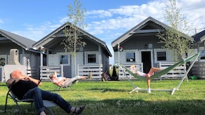 A row of cabins with outdoor seating areas and hammocks. - New Holiday Homes for 2 People in Dziwnowek (Kamien Pomorski)