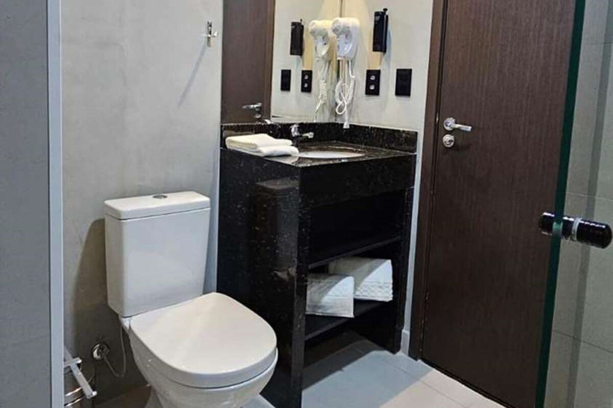 A compact bathroom with a toilet, a sink, and a mirror.
