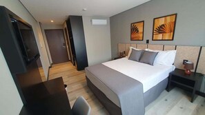 A hotel room with a bed, bedside tables, a desk, and artwork on the walls. - Tulip Inn Bauru (Bauru)
