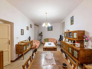 Ein gemütlicher Essbereich mit Holztisch, Stühlen und einer Chandelier.