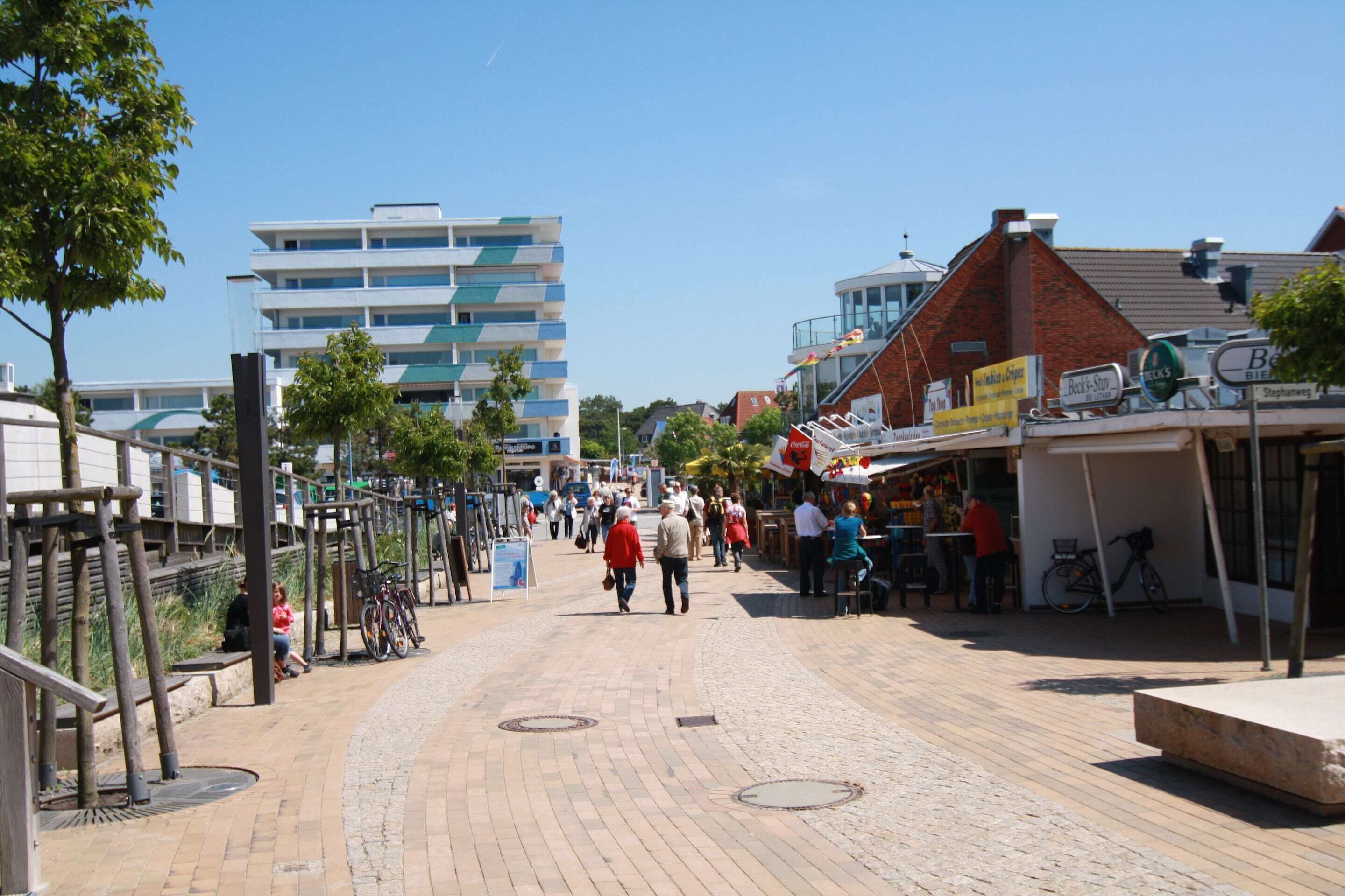 A pedestrian street with shops, benches, and bicycles.