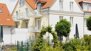 A row of modern, two-story buildings with red-tiled roofs and balconies. - Ferienwohnungen Grosser und Kleiner Seestern, Wiek (Wiek)