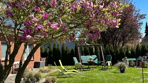 A garden with a swing set, outdoor furniture, and a bench.
