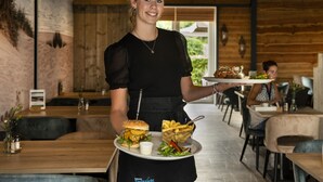 A restaurant interior with wooden walls, modern pendant lighting, and a casual dining layout. - Comfortable Chalet With Airco, on a Holiday Park, at Just 1 km. From the Beach (Koudekerke)