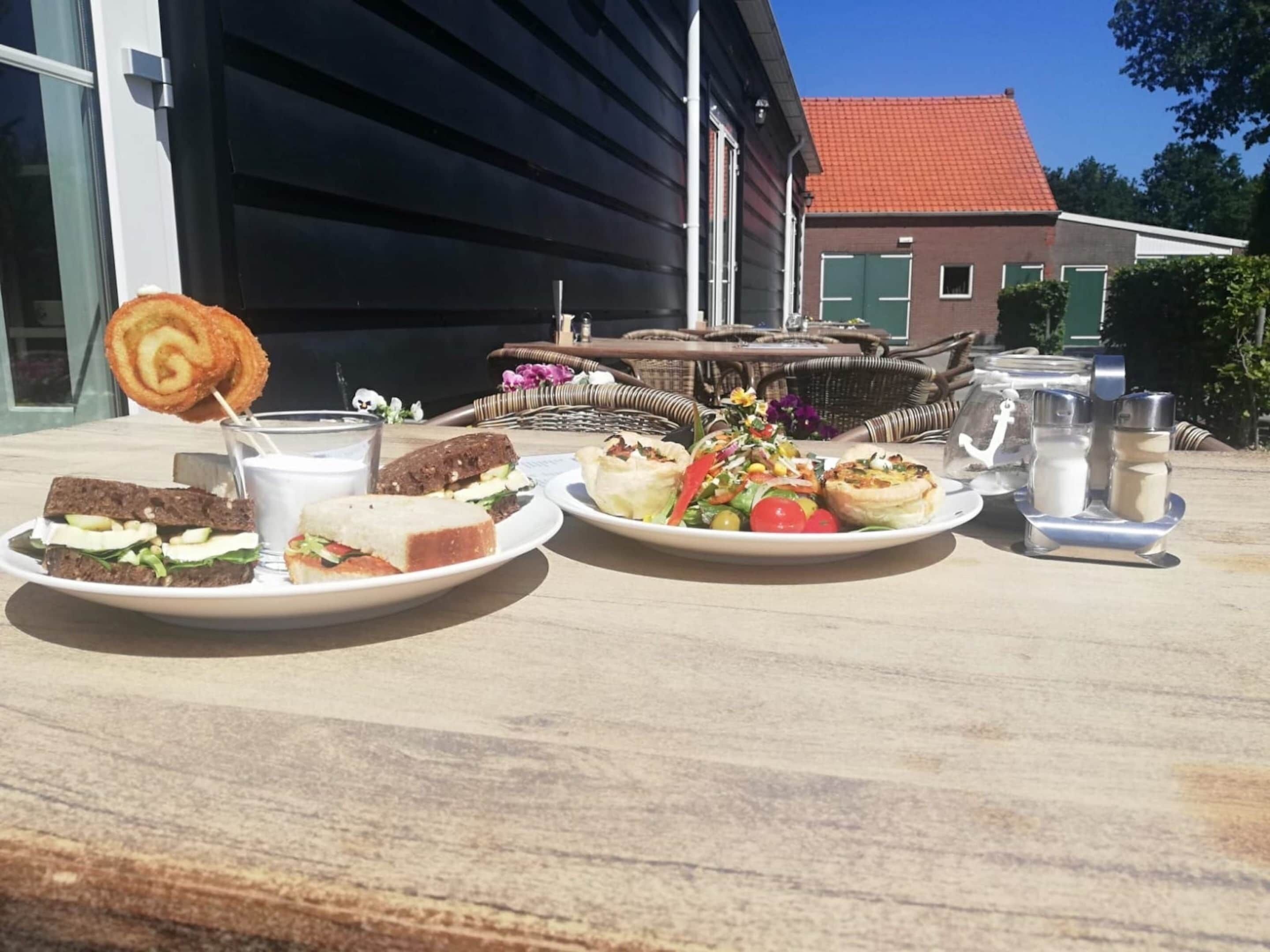 Une table sur laquelle on trouve divers aliments, notamment des sandwichs, une salade et une sucette.