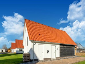 A building with a red-tiled roof, white walls, and a garage door. - Beautiful Holiday Home in Scherpenisse With Charming Terrace (Scherpenisse)