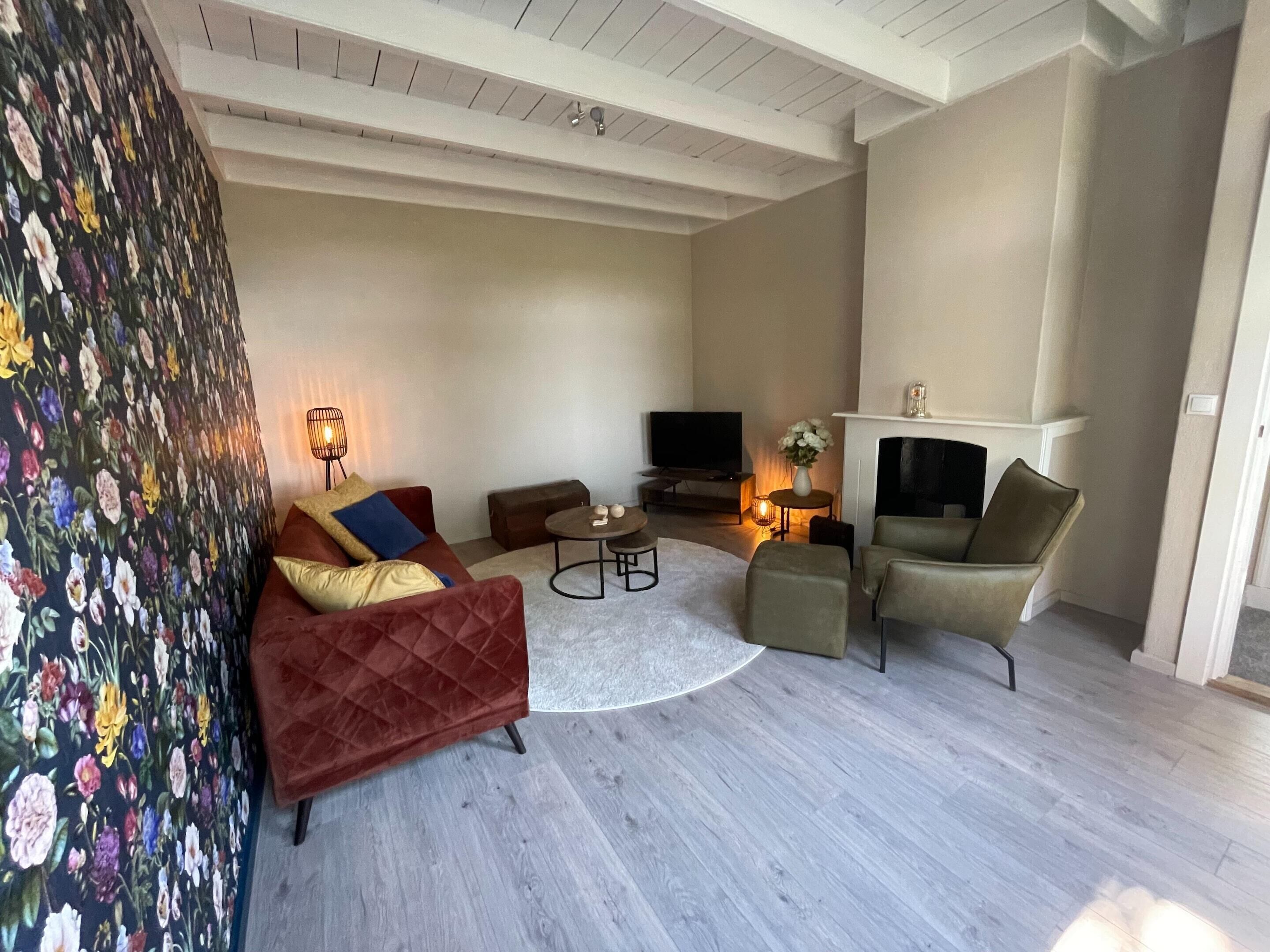 Un salon avec une cheminée, un téléviseur, un canapé et une table basse.