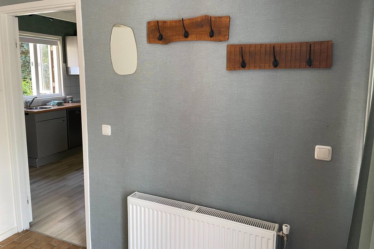 A kitchen with a window, a radiator, and wooden wall decorations.