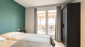 A bedroom with two beds, a sliding glass door to a balcony, and a dark wardrobe. - Charming House With Garden in Rural Area Hellendoorn (Hellendoorn)