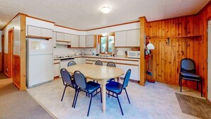 Una cocina compacta con una isla central, armarios blancos y un microondas.