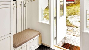 A room with a bench, a coat rack, a window, and a door leading outside. - 4 Person Holiday Home in Kyrkhult (Kyrkhult)