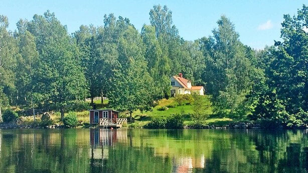 A house with a dock on a lake surrounded by trees. - 4 Person Holiday Home in Kyrkhult (Kyrkhult)