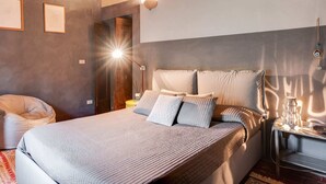A bedroom with a large bed, a wooden ceiling, a nightstand with a lamp, and a wall-mounted light fixture. - Belvilla by OYO Holiday Home in Molina di Quosa (San Giuliano Terme)