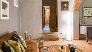 A cozy living room with a brown sofa, patterned cushions, a woven rug, and a tea set on a tray. - Belvilla by OYO Holiday Home in Molina di Quosa (San Giuliano Terme)