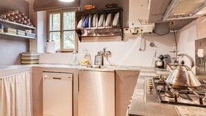 A compact kitchen with a dishwasher, stove, and a window providing natural light. - Belvilla by OYO Holiday Home in Molina di Quosa (San Giuliano Terme)