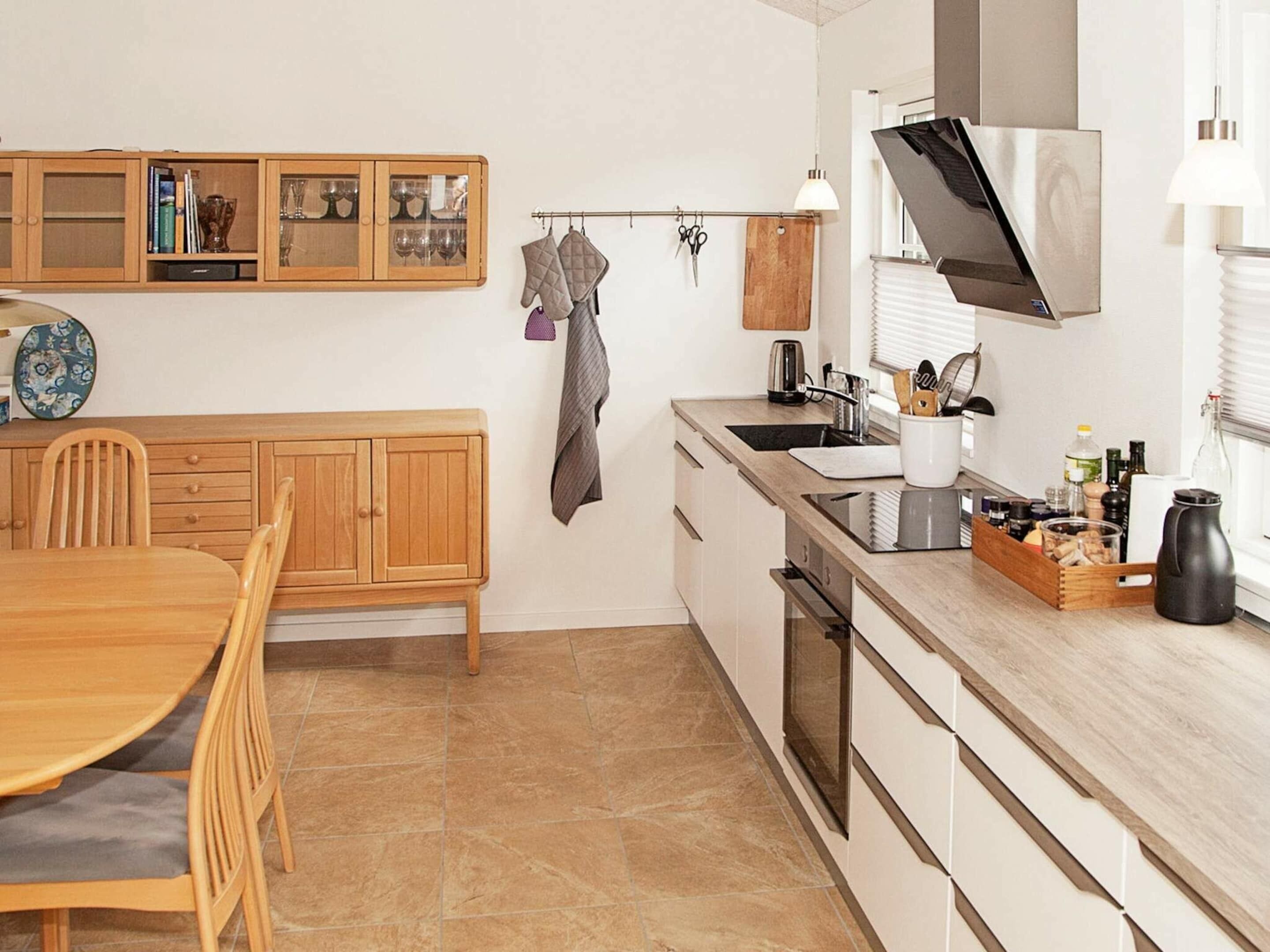 Una cucina moderna con mobili in legno, un tavolo da pranzo e un forno a incasso.