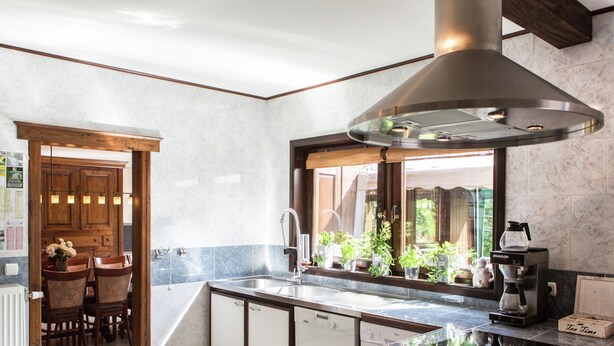 A modern kitchen with a central island, built-in oven, and a large window overlooking greenery. - Atmospheric Holiday Home in Durbuy With Sauna (Durbuy)