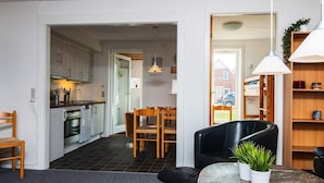 A compact living space with a kitchen, dining area, and a small seating area with a table and chairs.