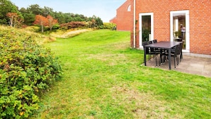 A brick building with a patio area featuring a table and chairs.