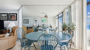 Un espace repas comprenant une table ronde et des chaises, un canapé et un téléviseur.