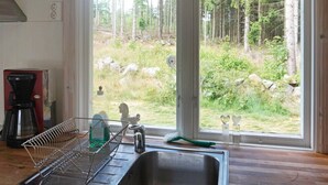 A kitchen with a large window, a coffee maker, and a dish rack. - 4 Person Holiday Home in Smedstorp (Smedstorp)