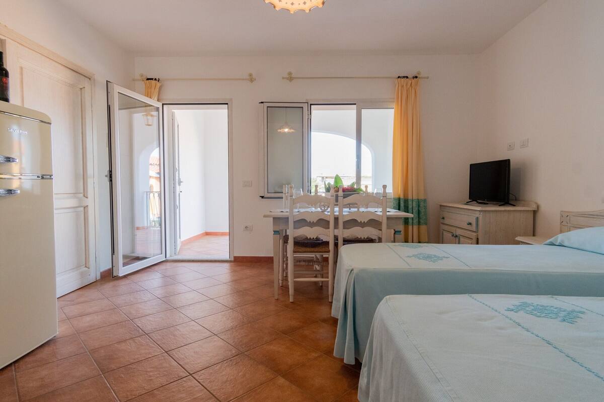 Une chambre d’hôtel équipée d’un lit, d’un bureau, d’une télévision et d’une armoire.