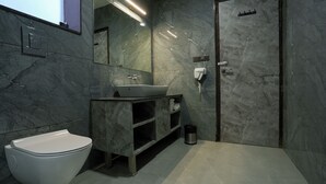A modern bathroom with a white toilet, a sink, and a mirror. - Bageecha Resort Pushkar (Pushkar)