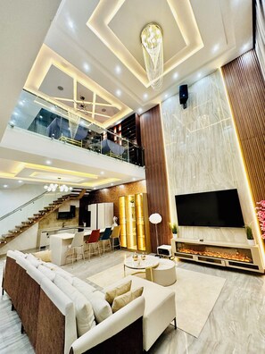 A modern living area with a sofa, TV, and a fireplace. - Lekki Villas (Lekki)