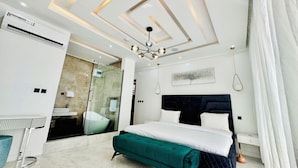 A modern bedroom with a large bed, a vanity, and a walk-in closet. - Lekki Villas (Lekki)