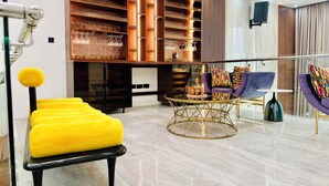 A modern living room with a yellow sofa, a purple armchair, and a coffee table. - Lekki Villas (Lekki)