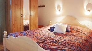 A bedroom with a bed, wooden wardrobe, and wall-mounted lights. - 6 Person Holiday Home in Kungshamn (Kungshamn)