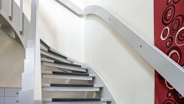 A staircase with white steps and black handrails, leading to a landing. - 6 Person Holiday Home in Kungshamn (Kungshamn)