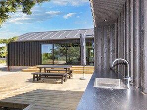 A modern building with a wooden deck, a metal sink, and a bench. - 5 Star Holiday Home in Romo (Rømø)