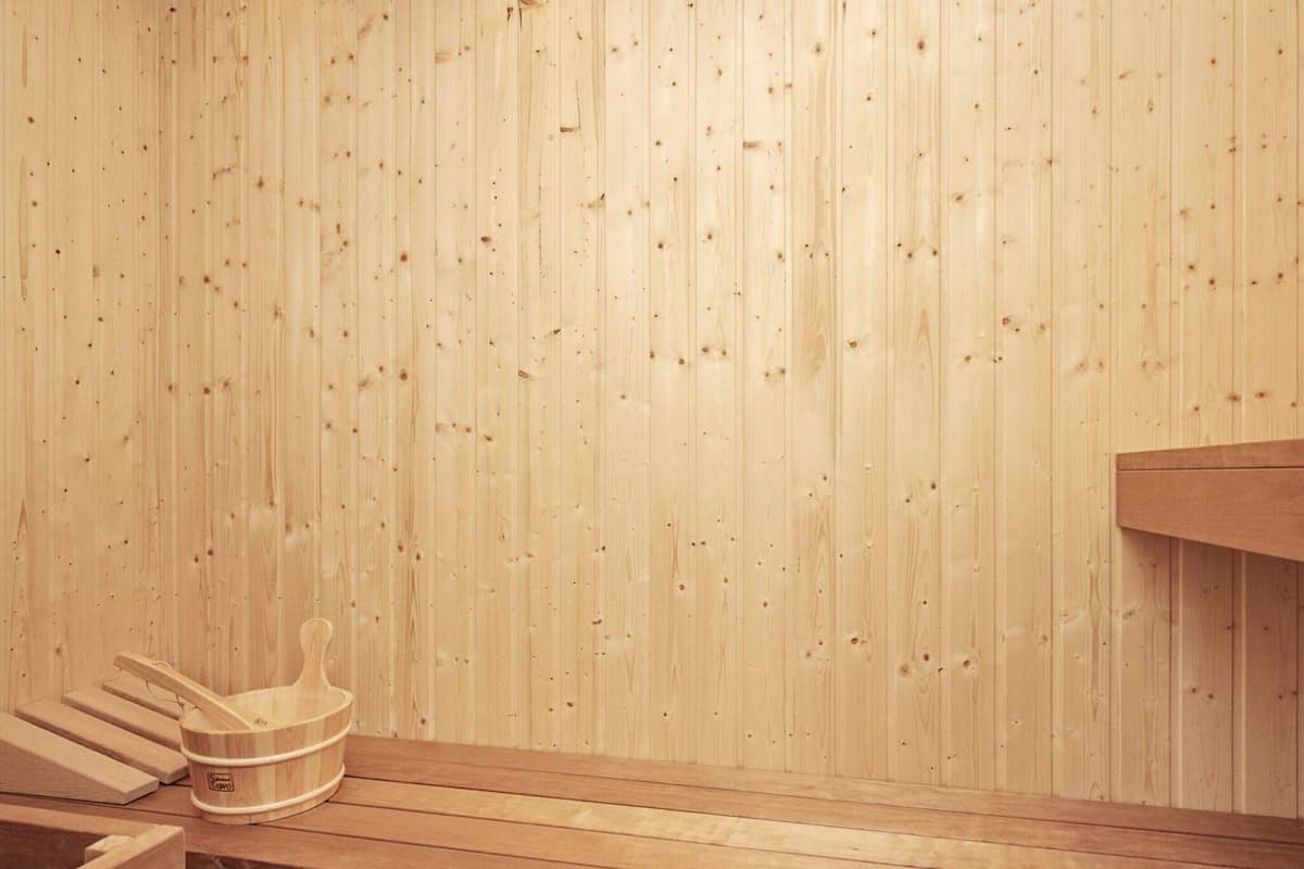 Un sauna avec des bancs en bois et un mur en bois.