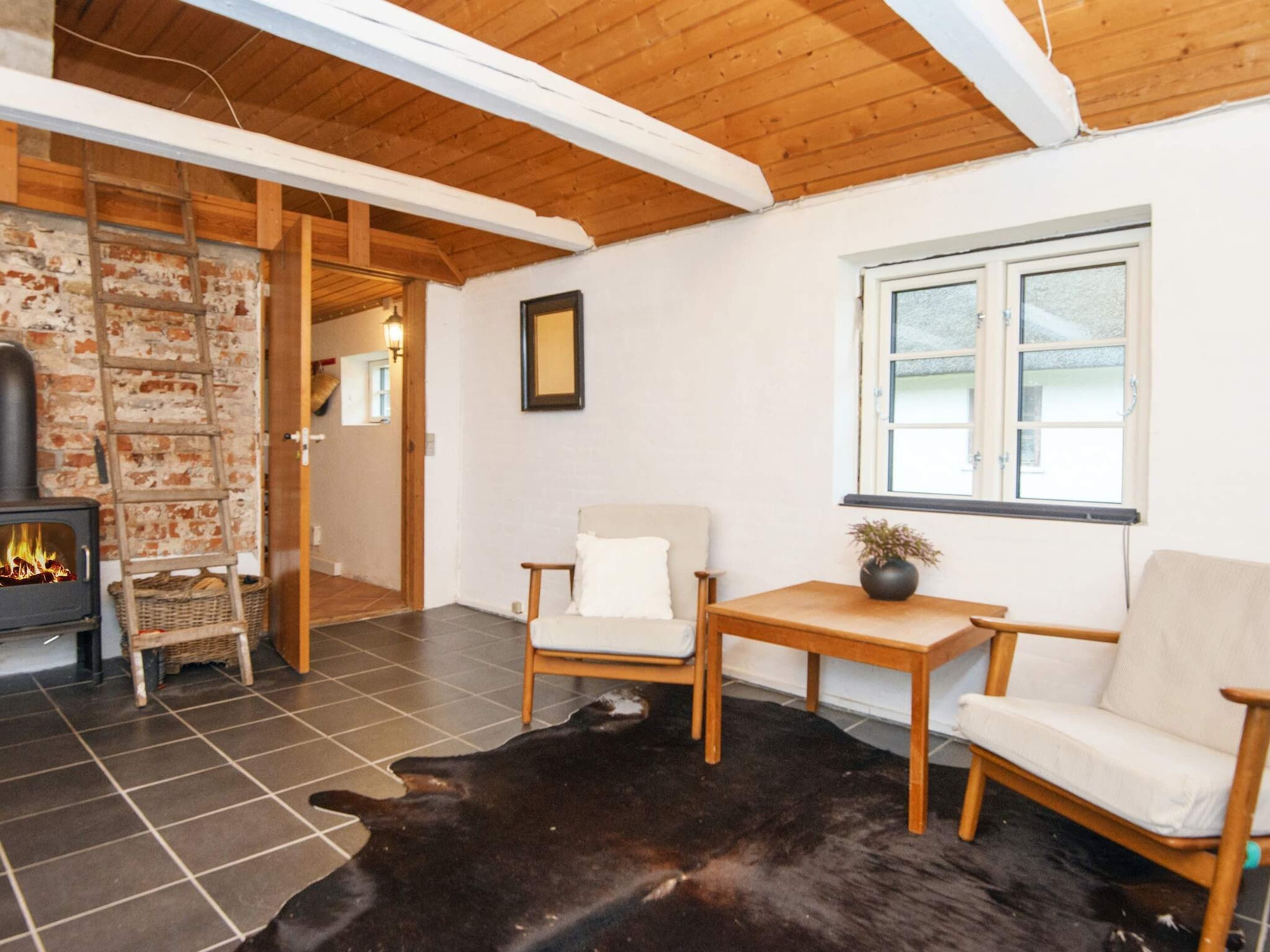 Un salón acogedor con chimenea, muebles de madera y una alfombra grande.
