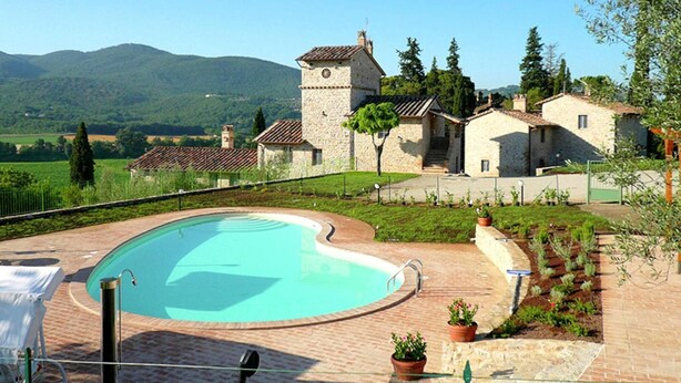 A stone building with a tower, a swimming pool, and a view of green hills. - Rustic Holiday Home in Corciano With Swimming Pool (Corciano)
