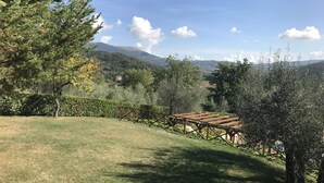 A grassy area with a wooden pergola and a view of a mountain range. - Rustic Holiday Home in Corciano With Swimming Pool (Corciano)