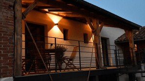 A covered outdoor area with a brick wall, wooden beams, and a railing.