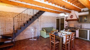 A rustic interior with a staircase, dining table, and kitchen area. - Apartment in a Farmhouse With 2 Swimming Pools (Cagli)