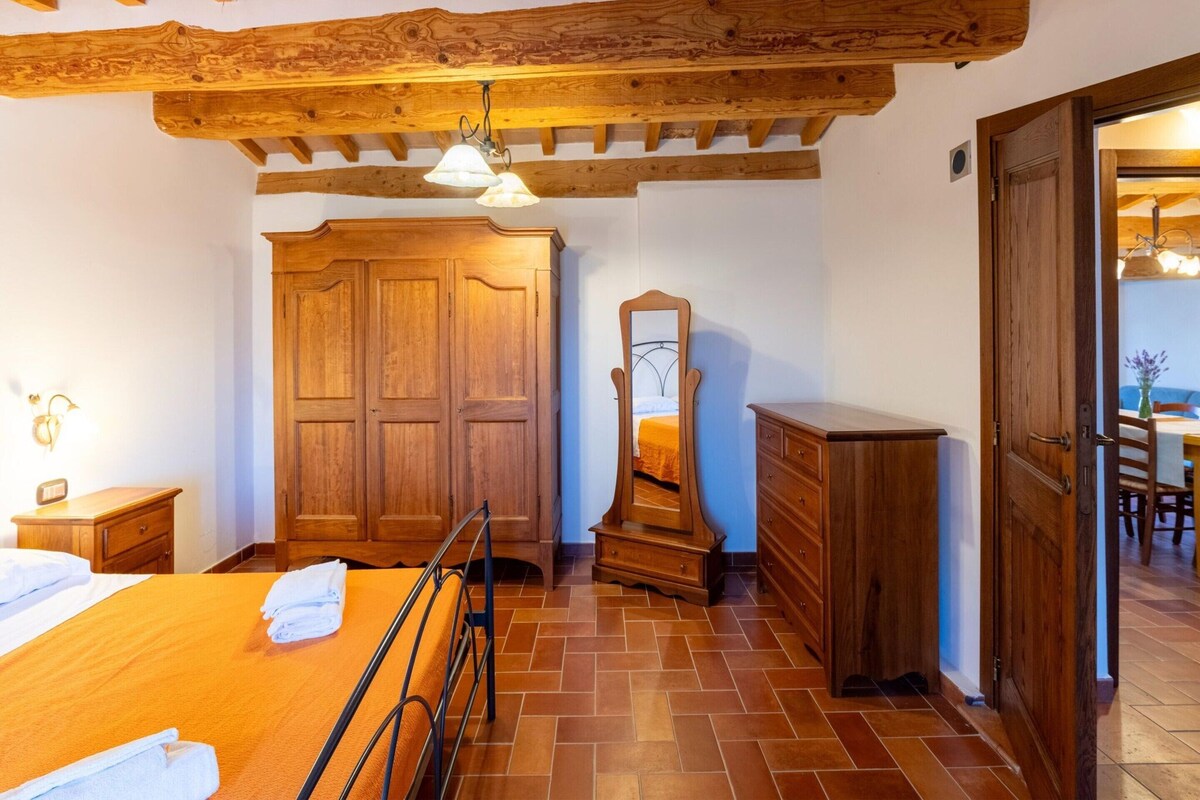 Ein Schlafzimmer mit einem Bett, einem Holzschrank, einem Schminktisch und einem Spiegel.