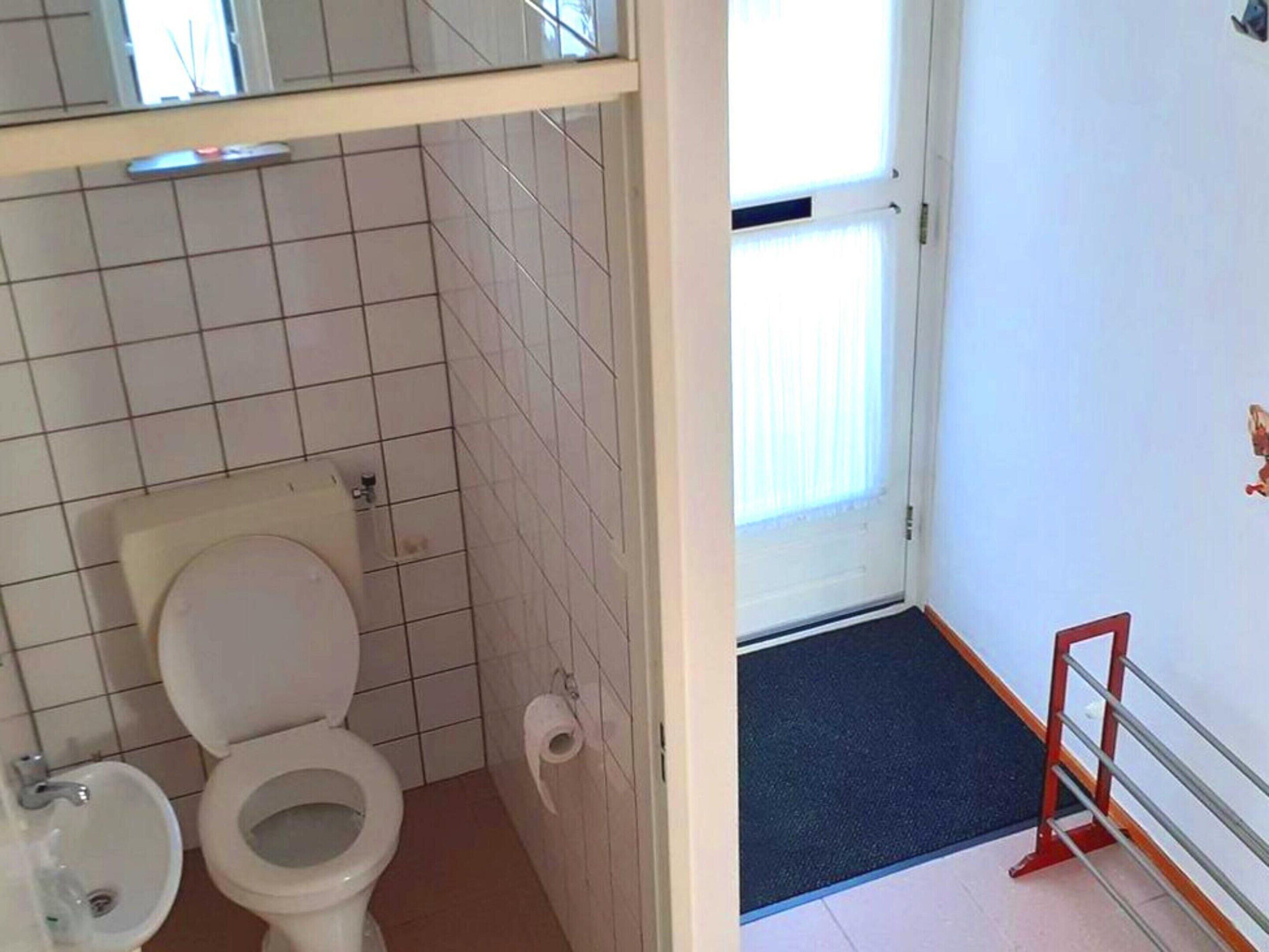 Een badkamer met toilet, bidet en wastafel.