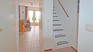 A staircase with a wooden handrail leading to a second-floor landing. - Cosy Bungalow Near the Beach (Breskens)