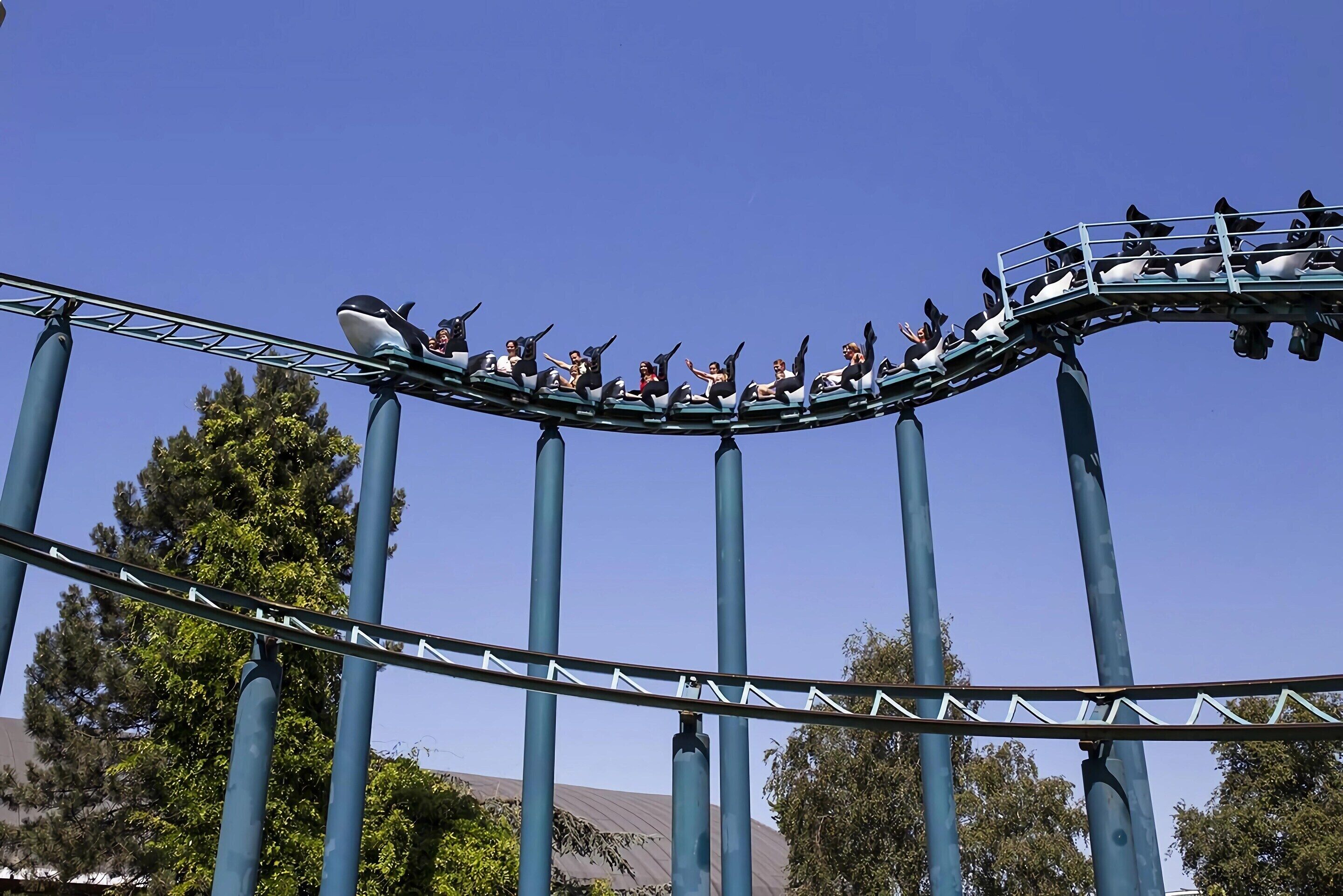 A roller coaster with passengers seated on it.