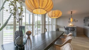 A modern kitchen with a central island, bar stools, and pendant lighting. - Fantastic Apartment Seaside With Terrace (Callantsoog)