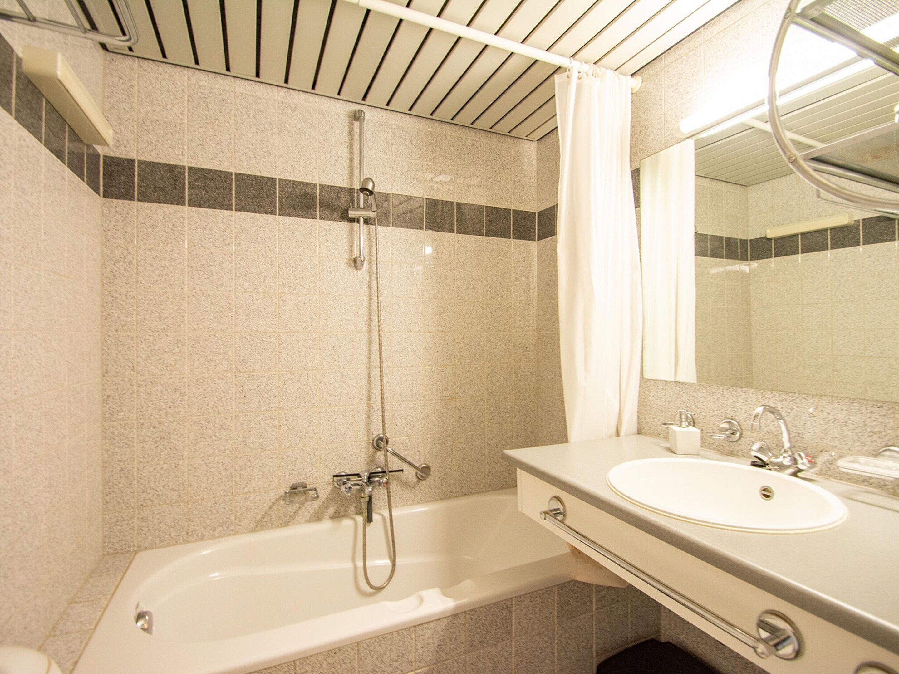 A bathroom with a bathtub, a sink, and a shower.