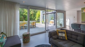 Ein modernes Wohnzimmer mit einer Couch, einem Couchtisch und einem Essbereich mit Stühlen und einem Tisch.