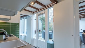 Eine moderne Küche mit großem Fenster, einer Spüle und einem eingebauten Backofen.