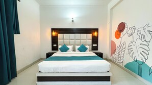 Un dormitorio con cama, mesitas de noche, cabecera y decoración en la pared.