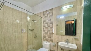 Un baño moderno con ducha de vidrio, inodoro y lavamanos.