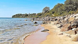 A beach with clear water, sandy shore, and rocky outcrops. - 4 Person Holiday Home in Ronne (Ronne)
